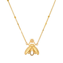 Gold-tone firefly pendant necklace with white topaz stone and beaded chain accents.