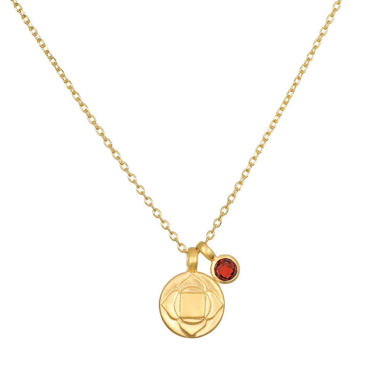 Gold-tone necklace with circular pendant featuring geometric chakra symbol and small red stone charm.