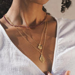 Model showcasing the Grounded in Positivity Red Garnet Root Chakra Choker layered with other spiritual necklaces, embodying a stylish talisman for meditation and protection, perfect for enhancing your personal energy in yoga and daily life.