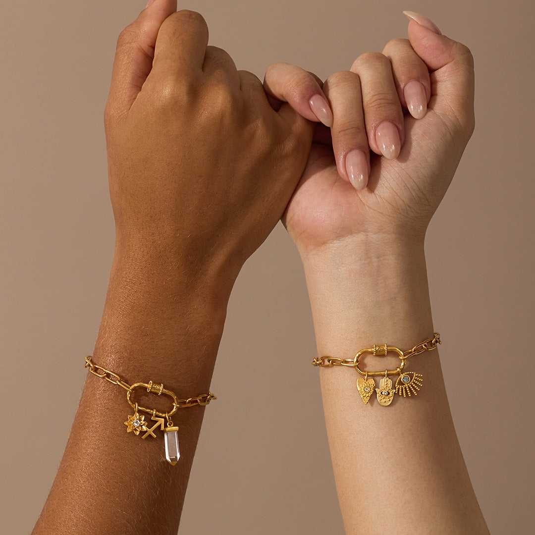 Gold-toned charm bracelet with linked chain and lotus-shaped pendant holder worn on wrist.