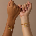 Gold-toned charm bracelet with linked chain and lotus-shaped pendant holder worn on wrist.