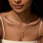 A model wearing the Protective Hand Hamsa Charm necklace, showcasing its elegant design. This piece of spiritual jewelry is ideal for those seeking protection and guidance, combining beauty with the deeper meaning of manifestation, complementing any yoga or meditation practice.