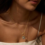 A model wearing the Celestial Alignment Charm necklace, highlighting the beautiful interplay of sun and moon motifs. This meaningful talisman is ideal for those into zodiac and spiritual journeys.