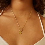 All Seeing Eye White Topaz Charm elegantly displayed on a delicate gold chain necklace worn by a model. This spiritual jewelry enhances meditation practices and acts as a protective charm, embodying the essence of sun and moon energies for meaningful manifestation in everyday life.