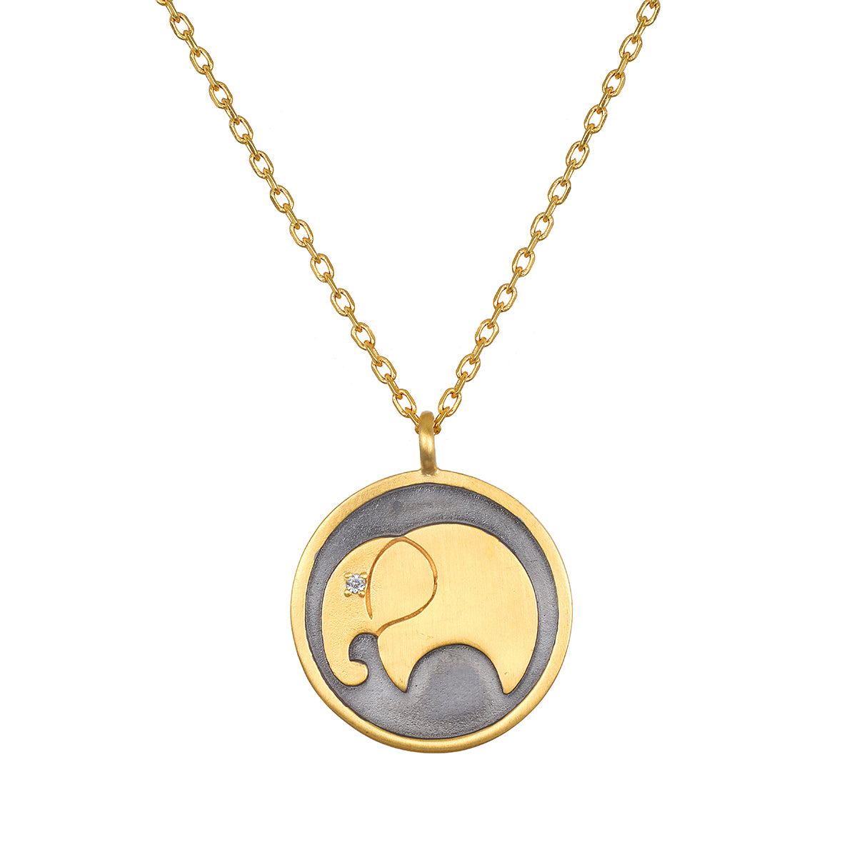 A gold chain necklace with a round pendant showing a gold elephant silhouette with a small clear stone eye on dark gray background.