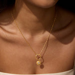 A woman wearing the Protect Your Magic Moonstone Charm on a delicate gold necklace, showcasing a stunning moonstone pendant. This spiritual talisman is ideal for those seeking connection through yoga and meditation, representing the harmony of the sun and moon in meaningful practices of protection and manifestation.