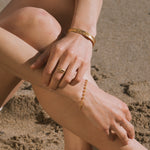 Gold ring with round yellow citrine stone worn on person's hand.