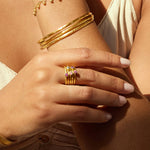 A detailed view of hands adorned with the Guided by Love Gemstone Stacked Ring, showing its shimmering gold and vibrant gemstones. This spiritual jewelry piece is ideal for enhancing meaningful intentions and fostering a connection to the sun and moon, making it a great companion for meditation and self-discovery.