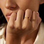 Close-up of a hand wearing the Inner Fire Garnet Ring, showcasing the faceted red garnet set in gold. This piece is ideal for yoga enthusiasts and those seeking spiritual protection, embodying the essence of meaningful jewelry for self-expression.