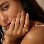 Gold ring with petal-shaped white topaz stone worn on ring finger.