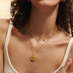 Close-up view of the Intention of Balance Necklace Set being worn, showcasing its intricate chakra symbols and gold-plated finish. This spiritual jewelry is perfect for meditation, providing a meaningful connection for those seeking balance and enhancement in their spiritual journey.