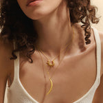 A model showcasing the Intention of Inspiration Necklace Set, layered with a golden starburst and crescent moon pendant. This spiritual jewelry serves as a beautiful reminder of meaningful intentions, ideal for yoga, meditation, and personal manifestation practices.
