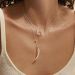 A model wearing the Inspiration Intention Necklace Set Silver featuring layered sterling silver pendants with a starburst and crescent moon, symbolizing spirituality and inspiration. This beautiful spiritual jewelry is perfect for meditation and represents meaningful intention setting in yoga practices.