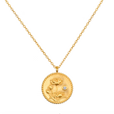 Joyful Beginnings Necklace features an intricate 18kt gold plated pendant adorned with lotus flowers and a white topaz stone, symbolizing new beginnings and individuality, perfect for spiritual jewelry, meditation, and meaningful charm.