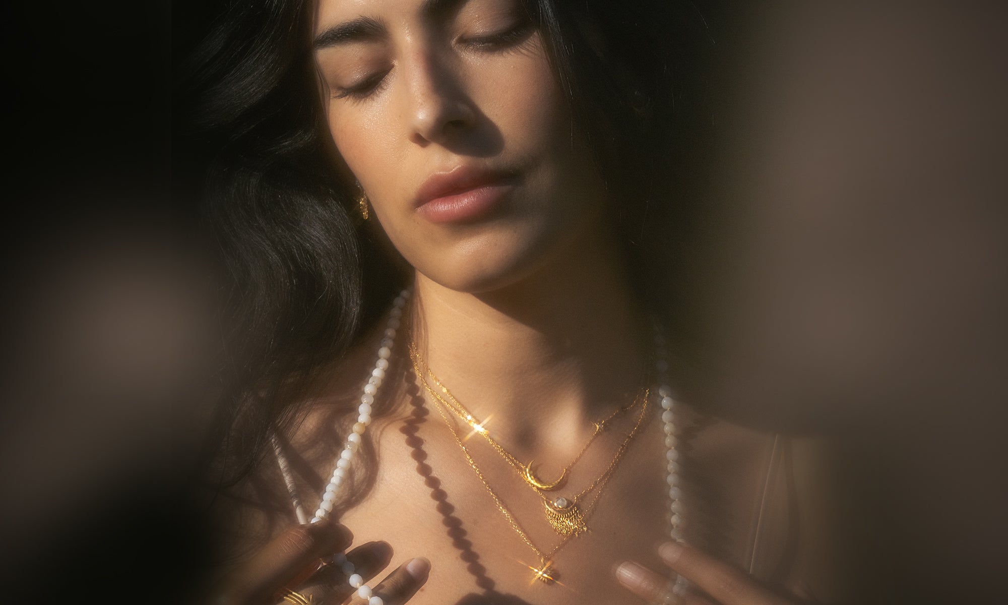 Close-up of a woman wearing gold necklaces with a blurred background