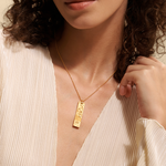 A model elegantly showcases the Story of Aquarius Zodiac Necklace, highlighting the intricate design of the pendant. This spiritual jewelry serves as a protective charm, linking to the zodiac sign Aquarius while inspiring creative energy and a deeper connection to the sun and moon. Ideal for meditation and yoga practices.