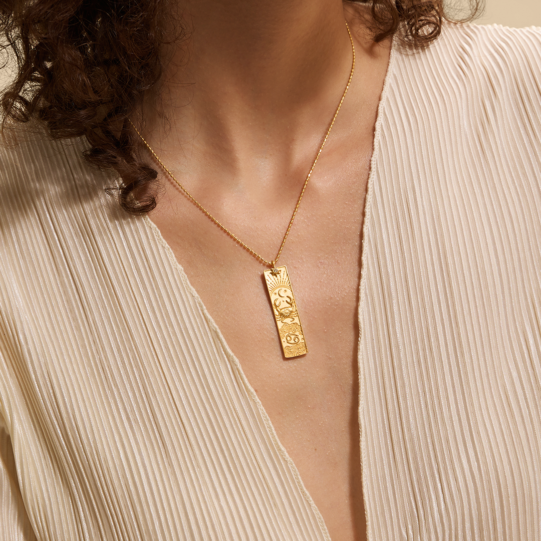 A model wearing the Story of Cancer Zodiac Necklace, highlighting its elegant design. This spiritual jewelry resonates with the energies of zodiac signs, promoting meditation and offering a meaningful symbol of protection, sun, moon, and spirituality.