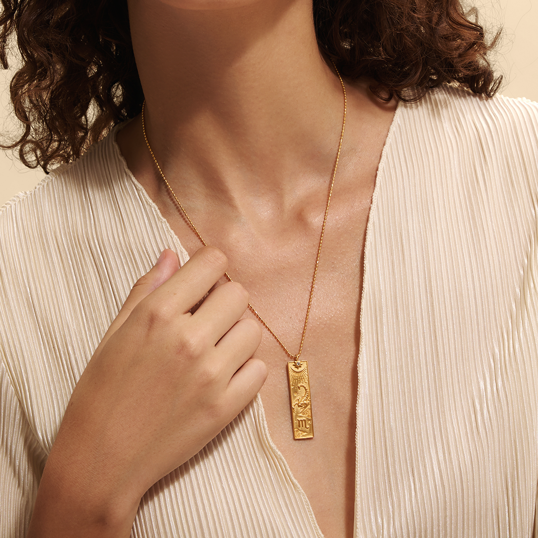 A person wearing the Story of Scorpio Zodiac Necklace, illustrating its elegant design and connection to the spiritual realm. This piece serves as a beautiful talisman, blending the power of zodiac symbolism with meditation, protection, and meaningful expression for spiritual seekers.