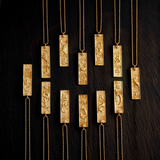 A collection of 12 beautifully designed Aquarius Zodiac Necklaces displayed elegantly, showcasing their intricate details. These spiritual jewelry pieces represent the essence of the Aquarius sign, perfect for meditation and as a talisman for zodiac enthusiasts. They embody meanings of individuality and creativity, making them ideal for charm and manifestation practices in yoga.