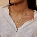 Woman wearing a Zodiac Glyph Charm necklace featuring the Leo symbol, symbolizing spirituality and personal meaning. This spiritual jewelry serves as a talisman for manifestation during meditation and yoga practices.