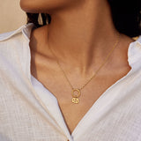 A woman wearing a Zodiac Glyph Charm Cancer pendant on a delicate gold chain. This spiritual jewelry piece symbolizes the protective qualities of the Cancer zodiac, making it a great talisman for meditation and meaningful expressions.