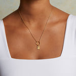 Celestial Rectangle Charm attached to a delicate gold chain necklace, embodying a spiritual jewelry piece that aligns with zodiac meanings. This stunning charm, representing the sun and moon, offers protection and serves as a meaningful reminder during yoga or meditation.