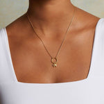 A close-up of a person wearing the Elephant Mini Charm on a delicate gold necklace. This spiritual jewelry piece embodies meaning and serves as a talisman for those who appreciate protection, meditation, and connection to the sun and moon energies in their yoga practice.