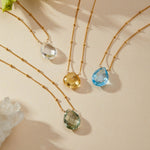 The Enveloped in Protection Crystal Necklace collection displayed with various crystal gemstones on gold chains, embodying protection, spirituality, and the essence of meaningful manifestation.