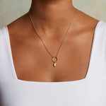 A model wearing the Hamsa Labradorite Charm on a delicate gold necklace, embodying spirituality and protection. This meaningful charm connects with the sun and moon energies, making it a beautiful talisman for zodiac enthusiasts and those seeking deeper meditation and manifestation.