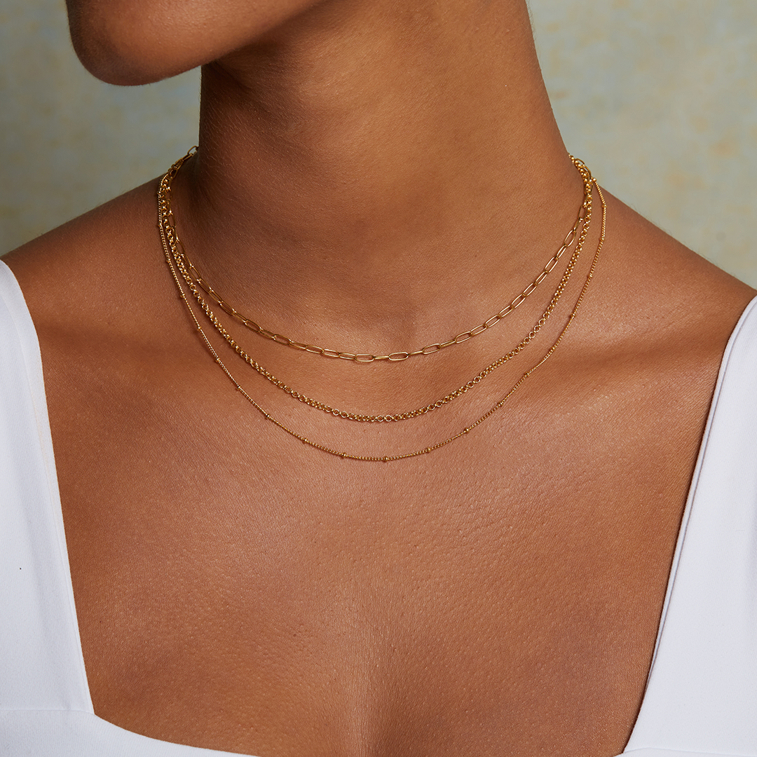 Close-up of the Layered Beauty Multiple Chain Necklace worn elegantly around the neck, highlighting its delicate layers. This necklace serves as a charming talisman, resonating with the energies of the sun and moon, perfect for those drawn to spirituality and zodiac meanings.