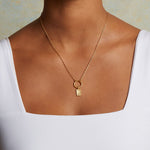 A model wears the Sunburst Rectangle Charm on a delicate necklace, showcasing its elegant design. This spiritual jewelry piece represents the essence of the sun and moon, promoting individuality and creativity, making it a meaningful talisman for those exploring their spiritual journey.