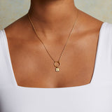 Model wears the Sun Square Charm necklace, an 18kt gold plated charm symbolizing vitality and leadership, perfect for spiritual jewelry and meaningful meditation practice. This talisman complements the themes of zodiac, malas, and yoga, enhancing protection and manifestation.