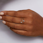 A hand elegantly showcasing the Diamond 14kt Gold Marquise Ring, entwined with other rings, representing meaningful and powerful spiritual jewelry. This combination reflects the essence of manifestation and yoga practices.