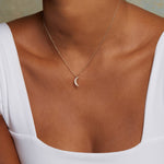 Model displaying the Moon Diamond 14kt Gold Pendant Necklace, highlighting its elegant design in a relaxed setting, perfect for those seeking spiritual jewelry that resonates with the moon's energy and adds meaning to their yoga and manifestation practices.