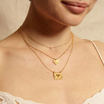 A model wearing the Heart Centered Gold Necklace layered with other delicate necklaces, showcasing a blend of elegance and spirituality—ideal for yoga enthusiasts and those seeking a talisman for protection and manifestation.