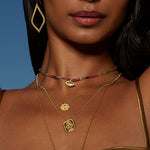 The Journey Forward Lotus Gold Necklace displayed among other spiritual accessories, highlighting its role as a talisman for manifestation and connection to zodiac energies, perfect for yoga enthusiasts.
