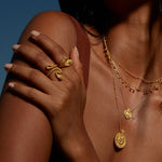 A woman displaying the Beauty is Timeless Snake Adjustable Ring on her hand, illuminated by sunlight. This impressive piece of spiritual jewelry serves as a talisman, rich in meaning, ideal for those embracing their journey of manifestation and self-awareness.
