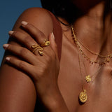 A woman displaying the Beauty is Timeless Snake Adjustable Ring on her hand, illuminated by sunlight. This impressive piece of spiritual jewelry serves as a talisman, rich in meaning, ideal for those embracing their journey of manifestation and self-awareness.