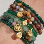 Close-up of the Personal Evolution Lotus Malachite Gemstone Bracelet stacked with various gemstones, representing a collection of spiritual jewelry for meditation, zodiac alignment, and meaningful connections.