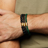 Close-up of the Path to Healing Malachite Gemstone Men's Bracelet paired with other beaded bracelets, featuring messages of truth and peace. This combination represents a powerful embodiment of spiritual and meaningful jewelry used in meditation and manifestation.