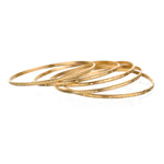 Gold Melody Bracelet Bangle showcased in a collection of thin stacking bangles, representing spiritual jewelry and meaningful designs perfect for yoga and meditation gifts.