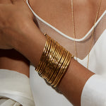 Gold Large Bangle Bracelet Cuff - Something Special showcased on a model's wrist, illustrating its beautiful layers and adjustability, ideal for those seeking protective and sacred spiritual jewelry, perfect for mantra and zodiac enthusiasts.