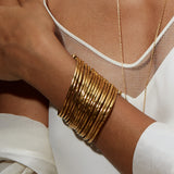Gold Large Bangle Bracelet Cuff - Something Special showcased on a model's wrist, illustrating its beautiful layers and adjustability, ideal for those seeking protective and sacred spiritual jewelry, perfect for mantra and zodiac enthusiasts.
