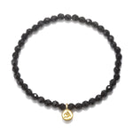 Om Black Onyx Gemstone Bracelet featuring faceted black onyx stones and a gold Om pendant, perfect for spiritual jewelry, meditation gifts, and yoga practices. This meaningful piece is a protective amulet embodying sacred and symbolic significance.