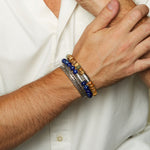 Deeply Rooted Picture Jasper Gemstone Men's Bracelet showcased on a wrist alongside other bracelets, ideal for yoga enthusiasts and those passionate about spiritual connection. This charm symbolizes protection and serves as a significant piece in spiritual and meditation practices.