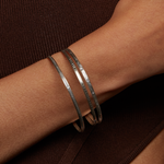 Close-up of a Silver Etched Bracelet Bangle titled Melody worn on a wrist, highlighting its elegant design, ideal for meaningful adornment in spiritual practices like yoga and meditation, serving as a protective amulet.