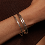 Close-up of a Silver Etched Bracelet Bangle titled Melody worn on a wrist, highlighting its elegant design, ideal for meaningful adornment in spiritual practices like yoga and meditation, serving as a protective amulet.