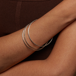 Showing multiple Silver Etched Bracelets Bangles titled Melody on a wrist, emphasizing their stylish appeal and symbolic meaning, making them great gifts for anyone interested in meditation, yoga, and spiritual jewelry.