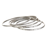 A collection of Silver Etched Bracelets Bangles titled Melody, showcasing various hand-stamped designs, perfect for spiritual jewelry and meditation gifts, embodying symbolic meaning and manifestation energy for yoga enthusiasts.