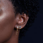Close-up of the Light Seeker Lapis Starburst Earrings worn by a person with curly hair. This spiritual jewelry serves as a talisman for protection and connection to zodiac energies, ideal for meditation and meaningful adornment.